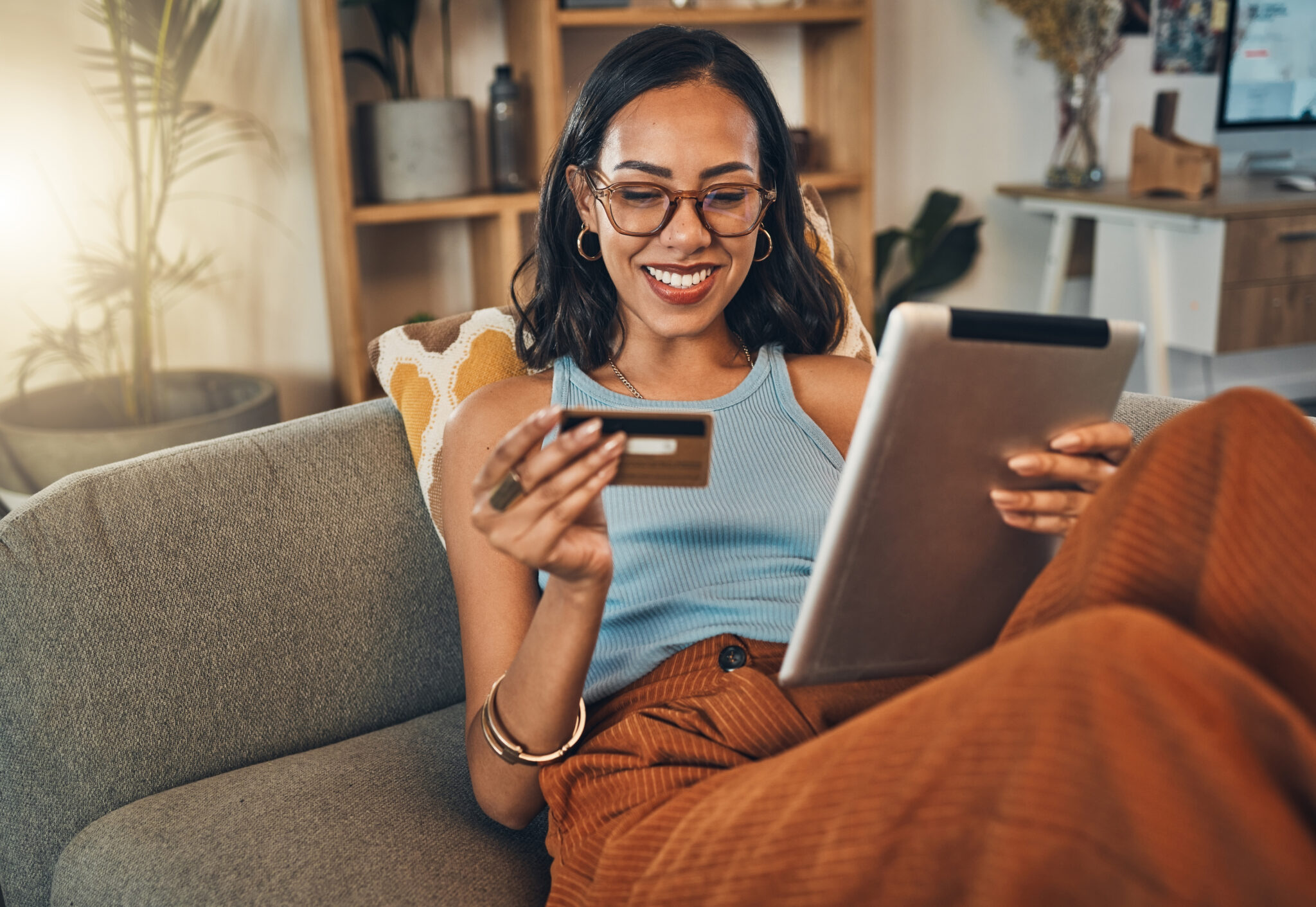 A woman holding her phone smiling with bright sun.